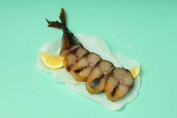 Concept of tasty food with smoked mackerel on mint background