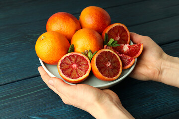 Female hands hold plate with red orange juice