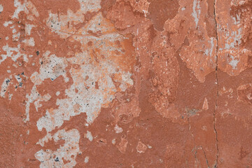 A stone wall with old paint of rough texture and cracks close-up. Background for designers.