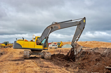 Fototapeta na wymiar Excavator digs the ground