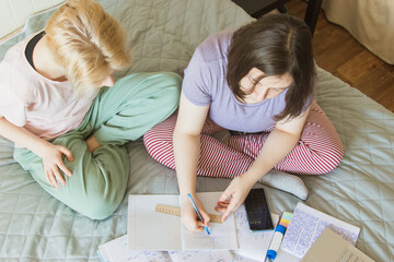 Education concept from above. Two gen z teenagers preparing exam.