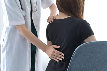 Physiotherapist examining female patient with back injuries. Physical therapy concept.