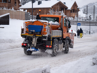 Road Vehicle Snowplow in action on Whitewashed Roads During a Snowy Day