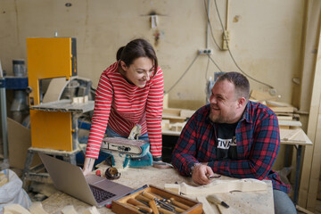 man and woman discussing a project in a carpentry workshop
