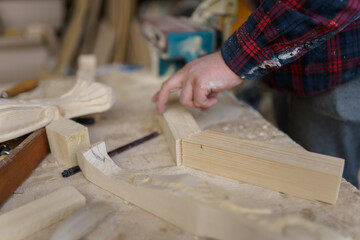 carpenter in a plaid shirt works in a workshop