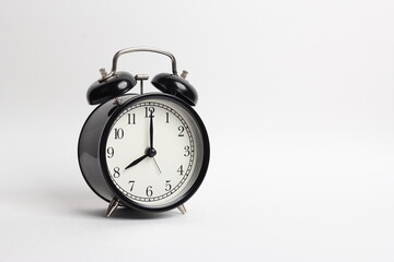 black vintage style alarm clock isolated on a white background