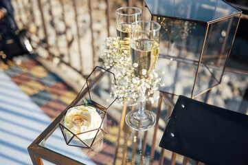 table for glasses with champagne for newlyweds at the wedding arch for ceremonies