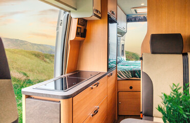 Interior of a camper van with kitchen and bed in the background