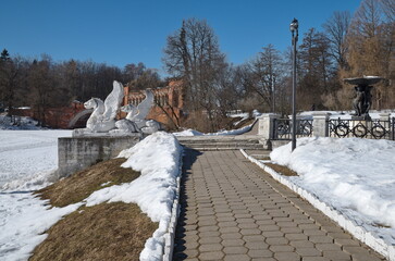 Marfino, Moscow Region, Russia - March 15, 2022: Sculptures of griffins on the pier and a cast-iron fountain in the Marfino estate