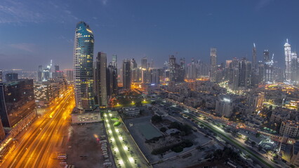 Fototapeta na wymiar Dubai's business bay towers aerial night to day timelapse. Rooftop view of some skyscrapers
