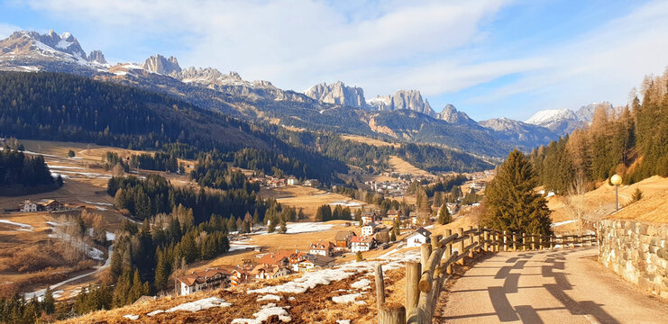 Panorama of Dolomites mountains and the city of Moena. View from above.