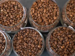 Coffee beans in glass jars standing in rows top view