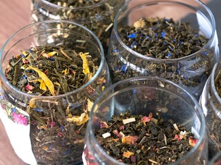 Tea of different varieties with pieces of fruit and dry leaves of herbs in glass jars