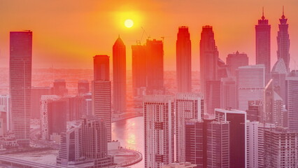 Fototapeta na wymiar Skyline with modern architecture of Dubai business bay towers at sunset timelapse. Aerial view