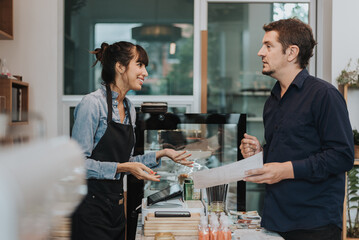 Caucasian woman barista take order from customer in coffee shop. female barista using digital tablet to take order. Coffee owner concept.
