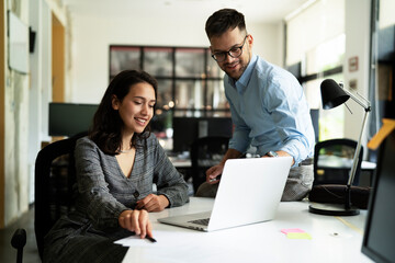 Colleagues in office. Businesswoman and businessman discussing work in office..