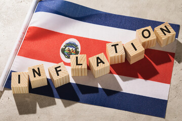 Flag of Costa Rica and wooden cubes with text, a concept on the theme of inflation in the country