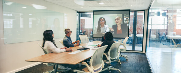 Modern businesspeople having a virtual briefing in a boardroom - obrazy, fototapety, plakaty