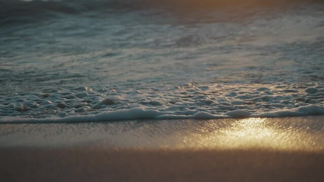 Prachtige weerspiegeling van de ondergaande zon in de wilde golven uit de stille ocean op het zandstrand La Punta in Puerto Escondido Mexico. Close-up following slwmo shot (PLEASE FIX LENGUAGE)
