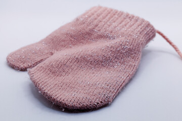 a pink knitted mitten for a little girl