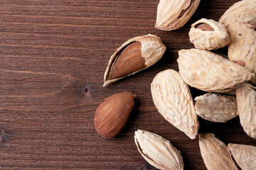 Salted almonds in a shell on a wooden background. Healthy proper nutrition, snack