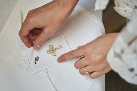 Women's Hands Straighten Out Baby's Christening Supplies