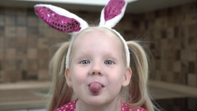 child makes faces and sticks out his tongue. Child girl makes funny faces and grimaces, close-up
