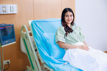 Happy smile successful Beautiful woman patient triumphing in modern hospital room EKG Monitor, success happy pose. Clean room with a bed in the new medical center