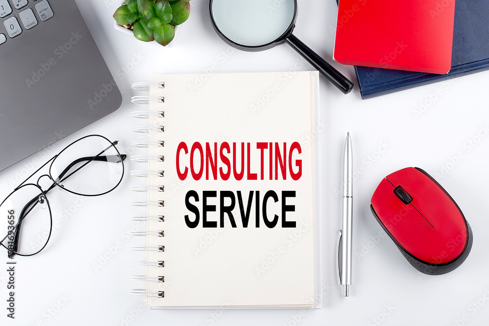 Poster consulting service text on a notepad with laptop on the white background