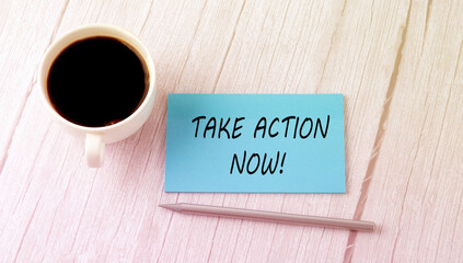 Take action Now text on the blue sticker with cofee and pen