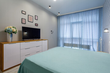Interior photography modern bedroom suite in hotel with large stylish bed, tv and crib