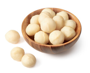Shelled Macadamia nuts in the wooden bowl, isolated on white background.
