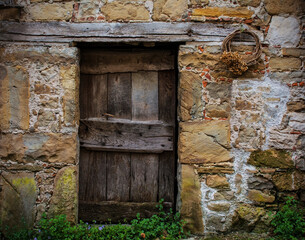 An old wooden door in a derelict house in Poffabro, an historic medieval village in the Val Colvera valley in Pordenone province, Friuli-Venezia Giulia, north east Italy
