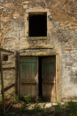 Fototapeta na wymiar An old wooden door and window in an historic derelict farm building in the village of Karojba near Buzet in Istria, western Croatia 