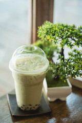 Iced bubble matcha green tea with artificial bonsai tree in Japanese style cafe
