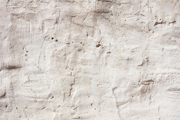 Background of a white plaster wall with imperfections in its texture.
