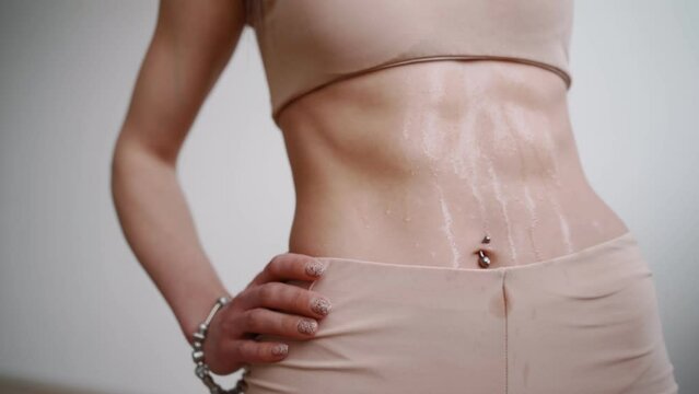 Close-up, Sweaty Female Belly After Cardio Workout. Concept of Weight Loss and Healthy Eating, Fitness and Abs Training. Unrecognizable Person.