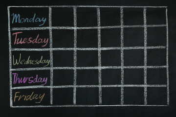 Weekly school timetable drawn on black chalkboard