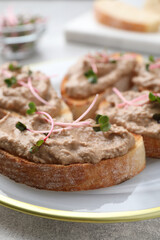 Slices of bread with delicious pate and microgreens on light grey table, closeup