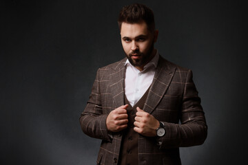 Handsome bearded man in stylish suit on dark background