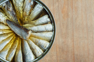 A close-up of a canned sardine on rustic weathered wood background with copy space. Fish and nutrition.