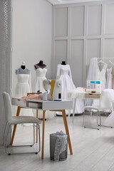 Dressmaking workshop interior with wedding dresses and equipment