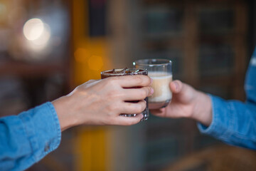 Close up of young couple hands clinking or toasting glasses of coffee talking sharing showing love and care, support, and Cheers, or business dealing, leisure time with friends idea. For Copy Space