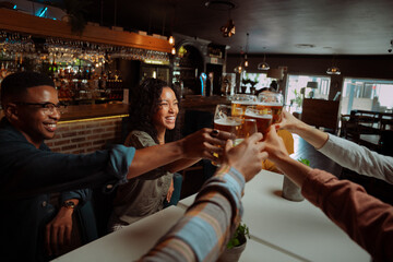 diverse group of friends out for drinks making a toast 