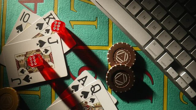 Top view of gaming table with computer keyboard, cards, dice and casino chips. Concept of gambling, online betting in casino. Play poker or texas holdem over internet. Playing a online gambling money.