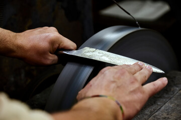 They grind while sharpening a large knife