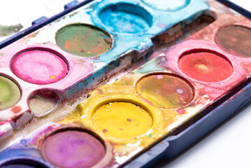 Blurry watercolor paints in close-up. Dirty paint packaging. Accessories for art work for children.