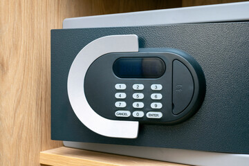 Close-up of code lock on opened iron safe door at hotel room