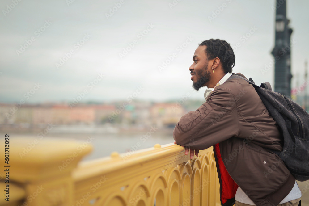 Wall mural young man on a bridge in budapest looks at the landscape