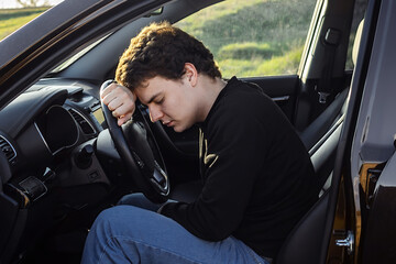the male driver cannot go further, he is tired and sleeps on the steering wheel of the car, rest during the journey